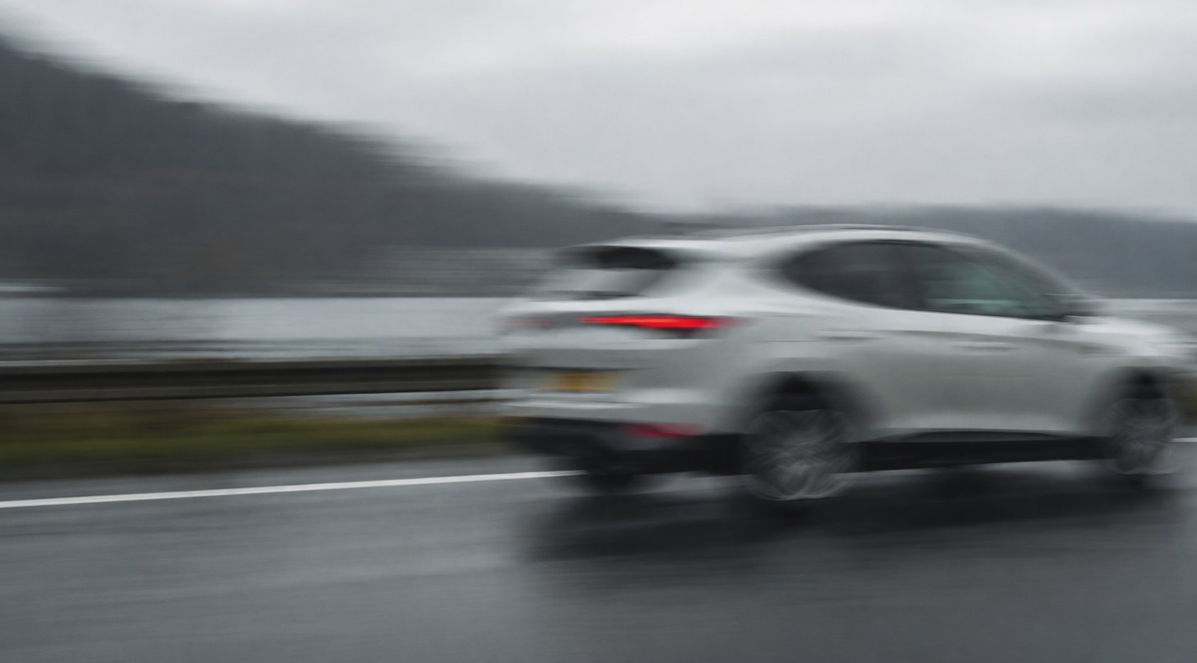 Rijdende auto op een natte weg, meegetrokken opname